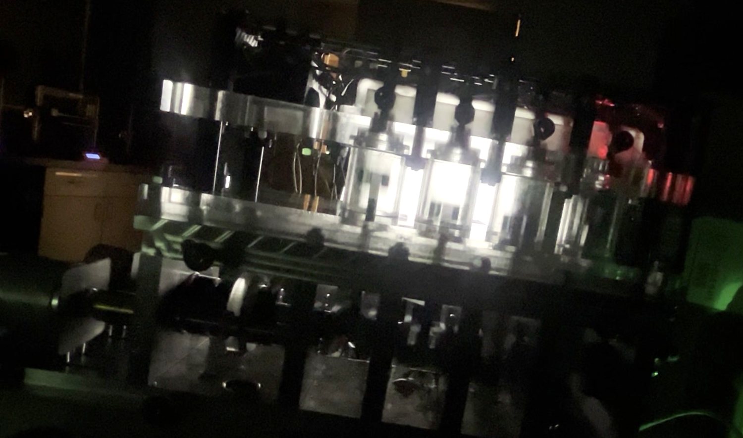 The model engine running in a dark room with its cylinders lit and a red combustion glow